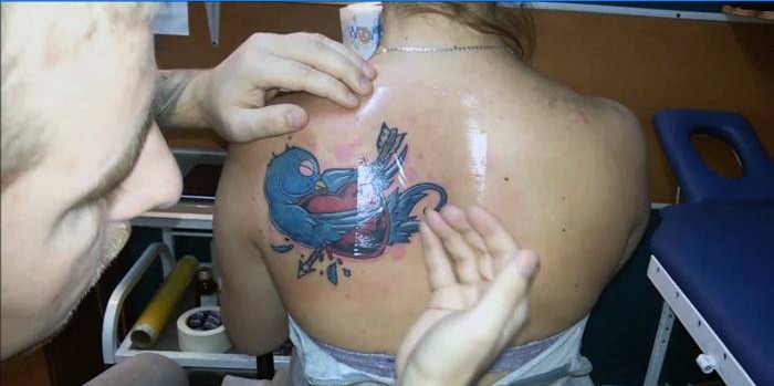 Master sætter en film på en tatovering