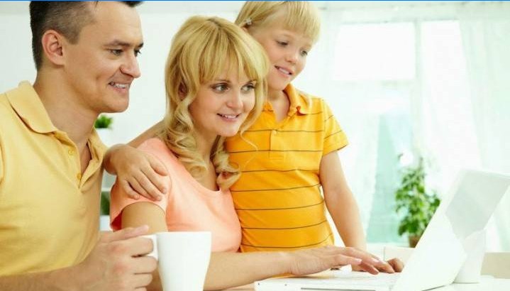 Familie med et barn ser på en computerskærm