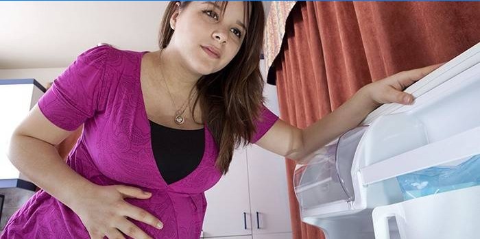 Kvinde på 8 måneder gravid holder sin mave