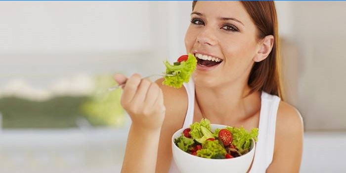 En pige i den tredje måned af graviditeten spiser en vitaminsalat