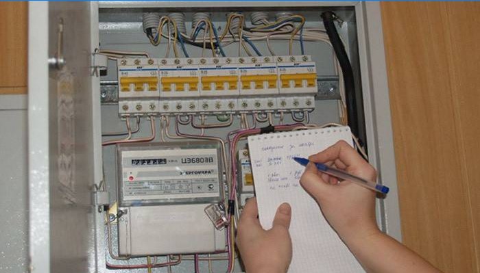 En mand registrerer aflæsningerne af en elektrisk måler