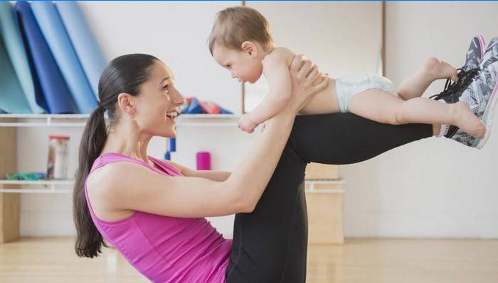 Pigen er engageret i fitness med et barn