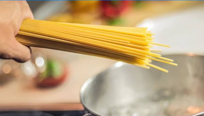 Spaghetti i hånden og gryden med vand