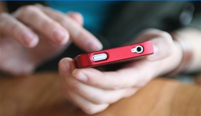 En mand holder en smartphone i hånden