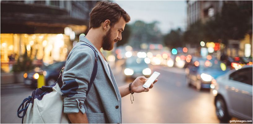 mand stikker ind i en smartphone