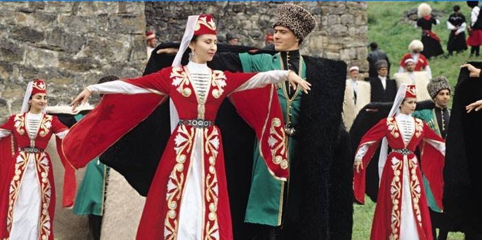 Kvinder og mænd i tjetjenske kostumer dans