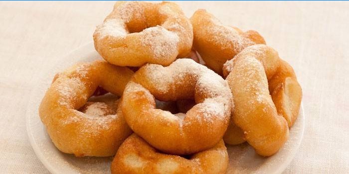 Donuts med et hul drysset med pulveriseret sukker