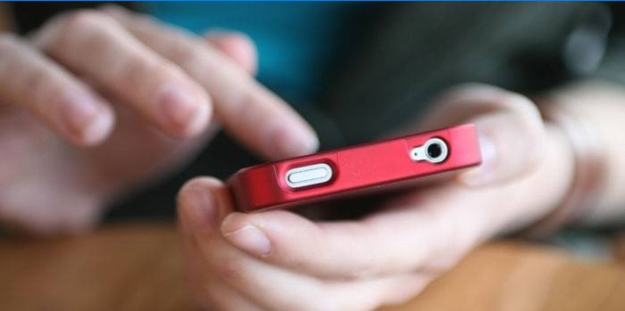Rød telefon i hænderne på en mand