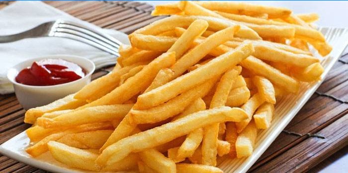 En plade med bagt pommes frites med tomatsaus