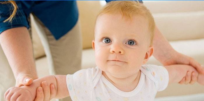 Kvinde holder toddler ved håndtaget