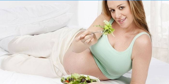 Gravid pige spiser salat