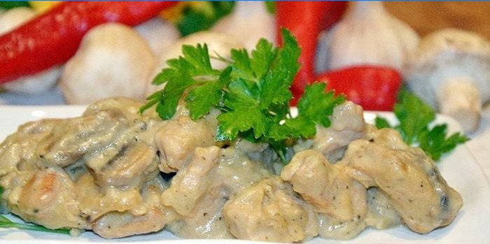 Braisede skiver af kalkunkød i en cremet sauce på en tallerken