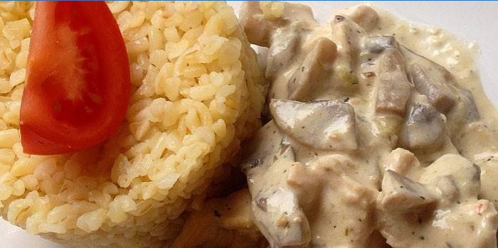 Skåret kalkunkød med svampe og ris på en sideskål