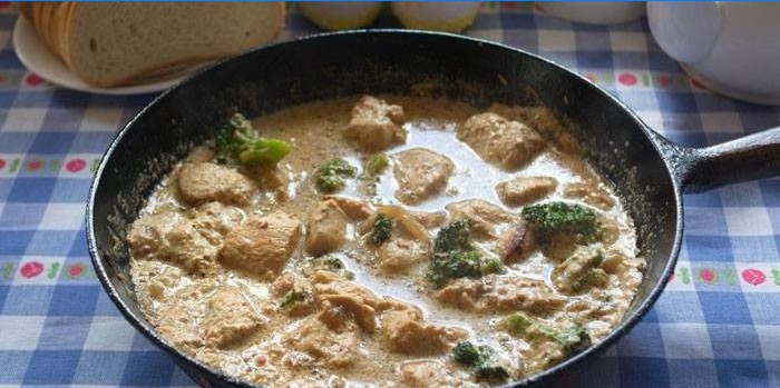 Braiserede skiver af kalkun med broccoli i en cremet sauce i en gryde