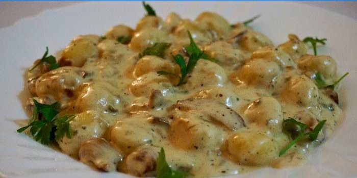 Brød kalkun i en cremet ostesauce på en tallerken