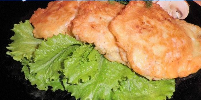 Tre kyllingefiletkoteletter på en tallerken med salat