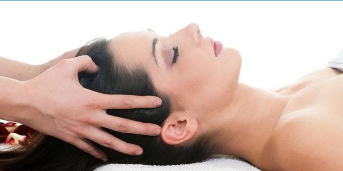 En pige får en hovedmassage for at stimulere hårvækst