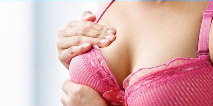 Kvinde, der udfører brystmassage til amning