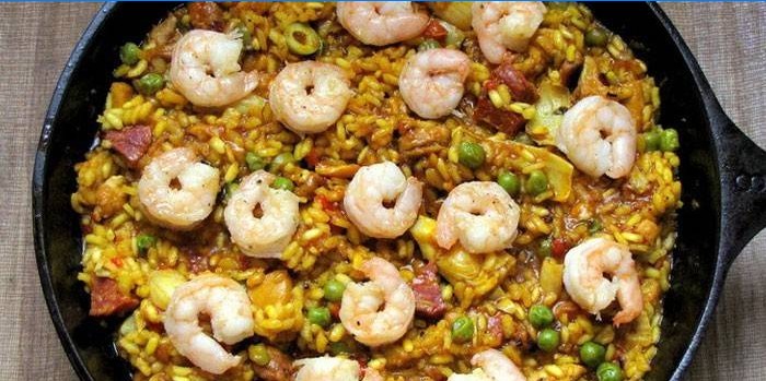 Paella med kød og rejer i en gryde