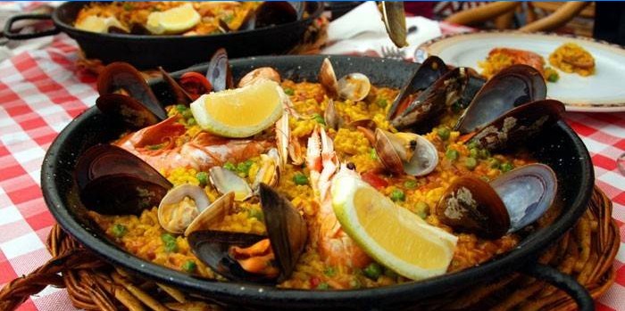 Færdiglavet paella med skaldyr og citron i en gryde