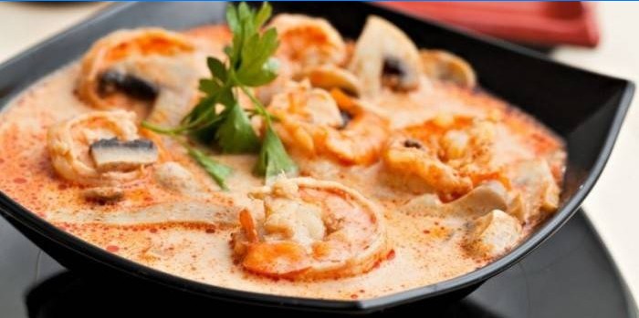 Tom yum suppe med svampe og rejer i en tallerken