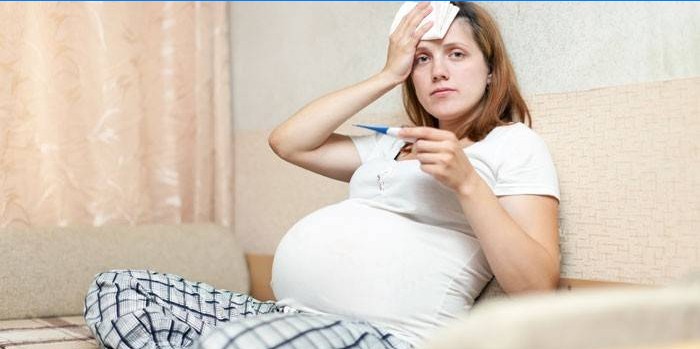 Gravid pige med et termometer