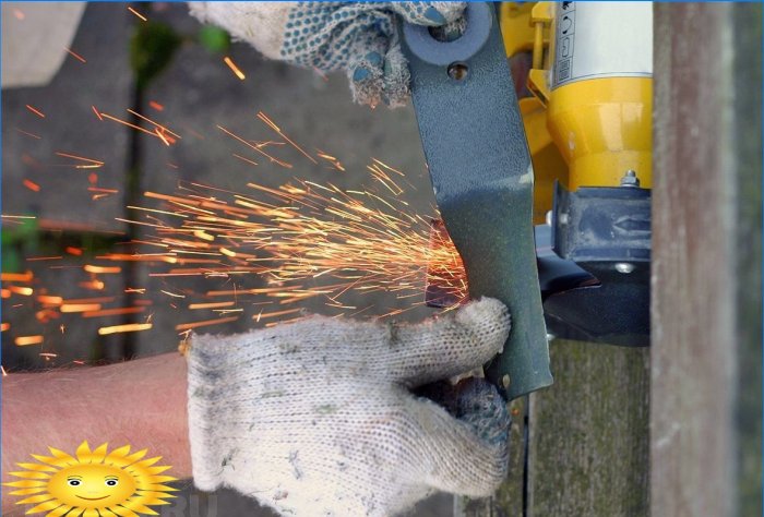 Slipning af en plæneklipper kniv på en slibemaskine