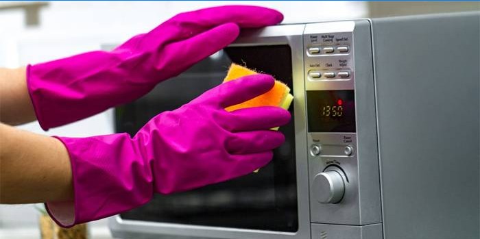 Kvinde vasker en mikrobølgeovn