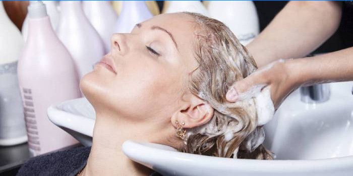 Blond kvinde vasker sit hår