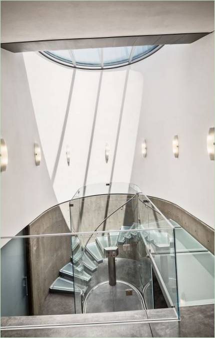 Trappe i glas og beton i halvrundt hus