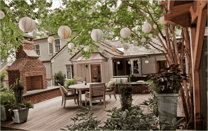 Landhus terrasse design - baggård med pejs og rundt bord