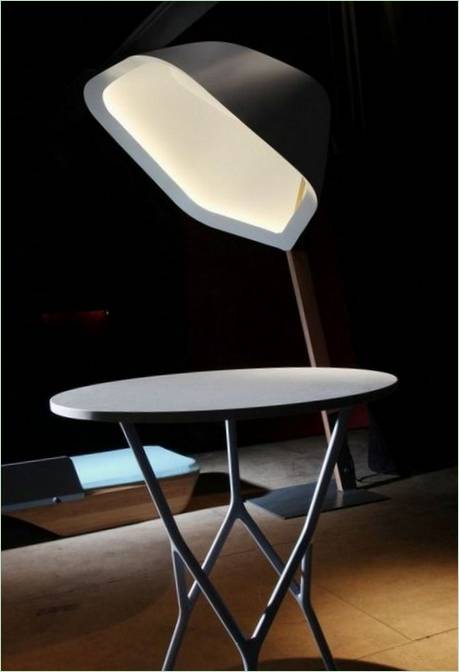 Sammensætning af dagligdags genstande: en bordlampe, et bord med gennembrudte ben..